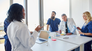 Group of healthcare professionals discussing something in a meeting, potentially related to Meta advertising for plastic surgeons in Eugene, OR